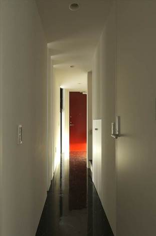 新宿の家テーマカラーは、黒・白・赤。1階サービスルームから玄関ホールを臨む。