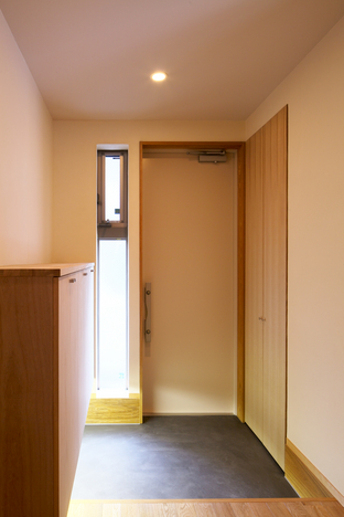 親世帯　玄関＿炭色のカラーモルタル塗土間